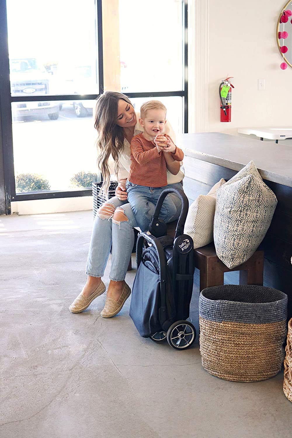 Parent folding Baby Jogger City Tour 2 with one hand